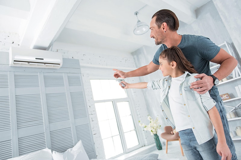 Positive joyful man pointing at the air conditioner
