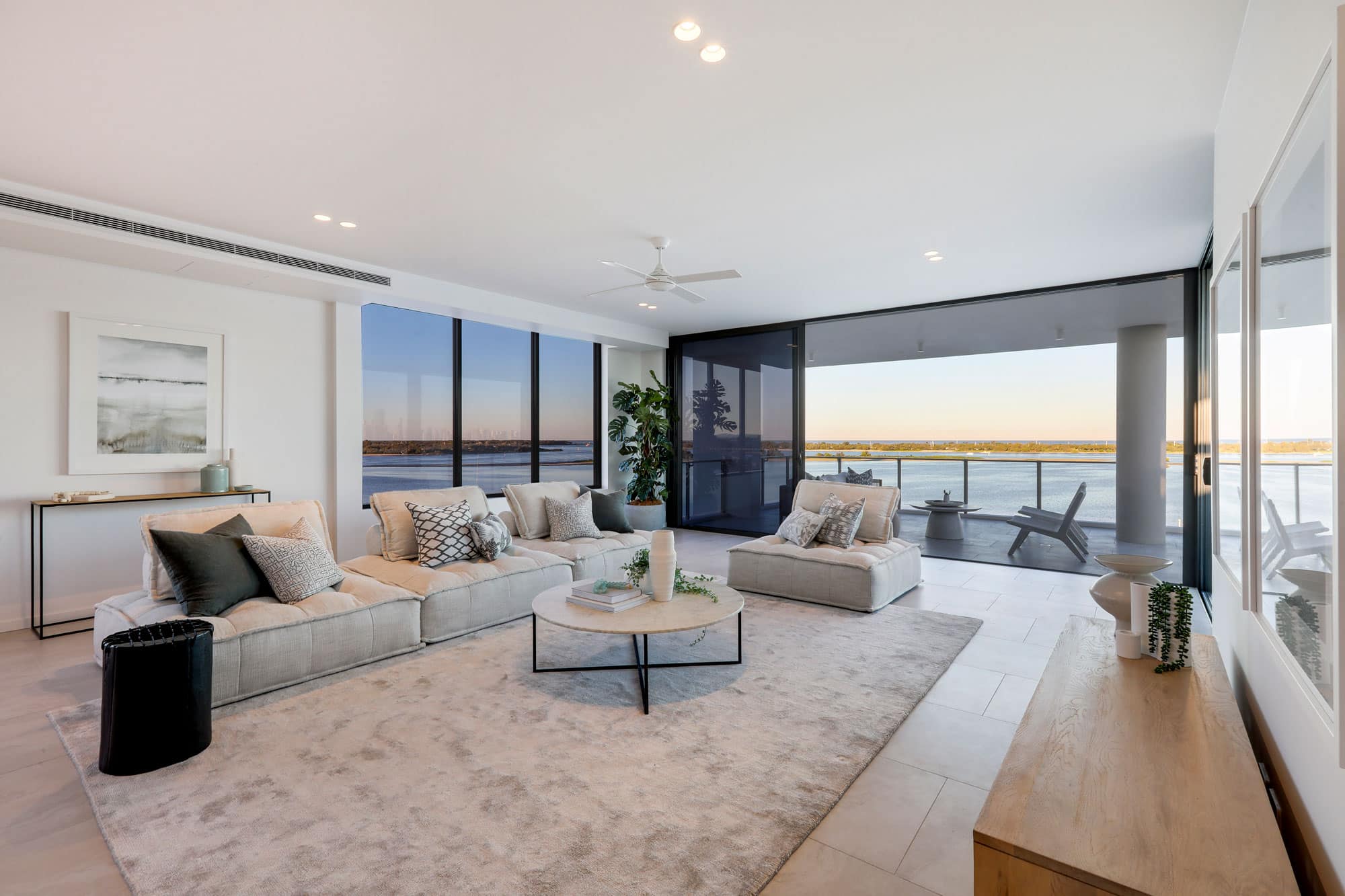 modern looking living room with a view of the sea with air slimline airconditioning vents
